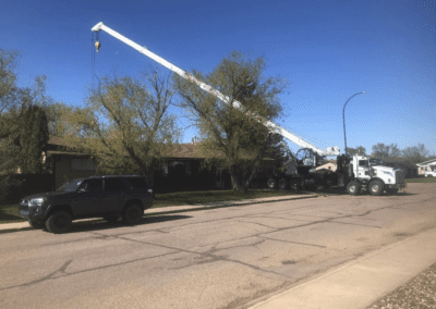 A crane lifts a large piece of equipment against a clear sky, showcasing its strength and precision in construction work.